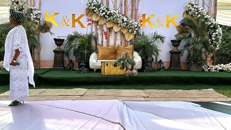 Wedding in Nigeria with a floral K and K backdrop